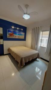1 dormitorio con 1 cama y una pintura en la pared en 100 metros da praia das Castanheiras,com garagem, internet, cadeiras de praia, cooler,roupas de cama e banho en Guarapari