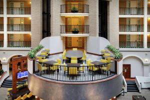 Embassy Suites Dallas - Park Central Area في دالاس: اطلالة على بهو الفندق مع وجود طاولات وكراسي