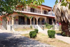a large building with a tree in front of it at Villa Apartment with 3 bedrooms in Polýkastron