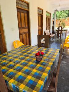 a table with a checkered table cloth and a basket of flowers on top at Thuruliya Residence in Sigiriya