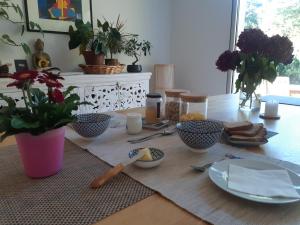 un tavolo con piatti e utensili sopra di Chambre d'hôte cosy & zen a Saint-Jean-la-Poterie