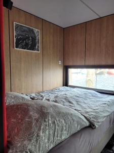 a bedroom with a large bed with a window at Houseboat of Grimm in Fehmarn
