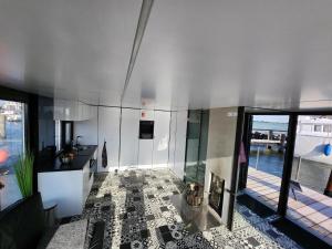 a large room with a tile floor and a kitchen at Houseboat of Grimm in Fehmarn