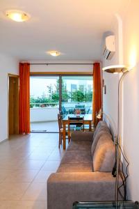 ein Wohnzimmer mit einem Sofa und einem Tisch in der Unterkunft Varandas do Mar Apartamento T2R frente mar Olhos de gua Albufeira in Olhos de Água
