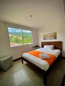 um quarto com uma cama grande e uma janela grande em HOTEL RIVERA CENTRAL em Bucaramanga