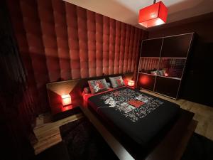 GH Apartment Vratza في Vratsa: غرفة نوم بسرير وجدار مبطن احمر