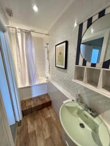 a bathroom with a sink and a mirror and a tub at 3 bed penthouse flat with conservatory & roof terrace - city views in Bristol