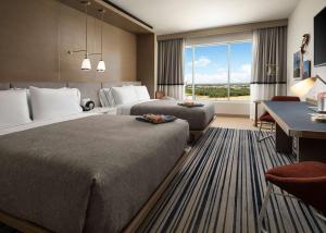 a hotel room with two beds and a desk at Canopy By Hilton Dallas Frisco Station in Frisco