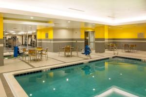a swimming pool with tables and chairs in a building at Homewood Suites- Denver Downtown Convention Center in Denver