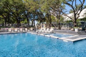 uma piscina com espreguiçadeiras e uma piscina em Hilton Dallas Lincoln Centre em Dallas