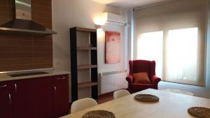 cocina con mesa y silla roja en Apartamento LA CORREDERA en Arenas de San Pedro