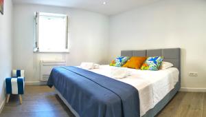 ein Schlafzimmer mit einem großen Bett mit einer blauen Decke in der Unterkunft Rose - Heart of Zadar in Zadar