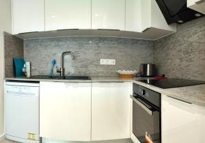 eine Küche mit weißen Schränken und einer Spüle in der Unterkunft Rose - Heart of Zadar in Zadar + 19 Fotos