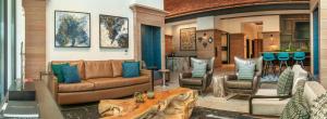 a living room with a couch and two chairs at Canopy By Hilton Dallas Uptown in Dallas