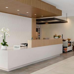 a lobby with a reception counter with a vase of flowers at Hilton Garden Inn Grapevine At Silverlake Crossing, Tx in Grapevine