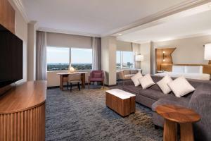 Habitación de hotel con sofá y cama en Hilton Dallas Lincoln Centre en Dallas