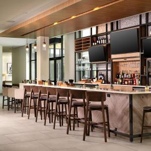 a bar in a restaurant with a bunch of stools at Hilton Garden Inn Grapevine At Silverlake Crossing, Tx in Grapevine