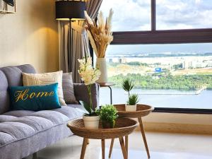 Loft Suite Seaview Near Johor Bahru Custom 7 pax في جوهور باهرو: غرفة معيشة مع أريكة ونافذة كبيرة