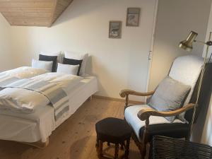 1 dormitorio con 1 cama y 1 silla en Thyholm B&B en Thyholm