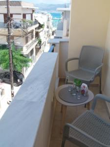 Katerina sitia apartments 1 في سيتيا: شرفة مع كرسيين وطاولة على مبنى