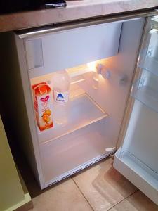 - un réfrigérateur ouvert avec une bouteille de lait et de l'eau dans l'établissement Katerina sitia apartments 1, à Siteía