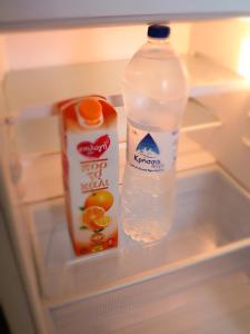 Katerina sitia apartments 1 في سيتيا: ثلاجة مع زجاجة مياه وحاوية عصير برتقال