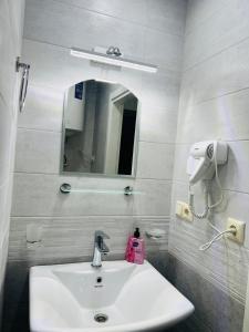 a bathroom with a sink and a mirror at Apartment in Orbi Beach Tower in Batumi
