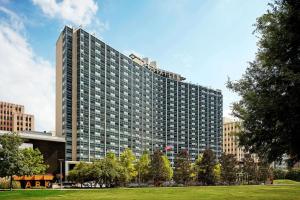 un palazzo alto con un parco di fronte di The Statler Dallas, Curio Collection By Hilton a Dallas