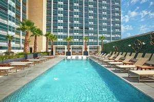 uma piscina com espreguiçadeiras e um edifício em The Statler Dallas, Curio Collection By Hilton em Dallas