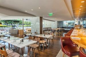 a restaurant with tables and chairs and a bar at The Statler Dallas, Curio Collection By Hilton in Dallas