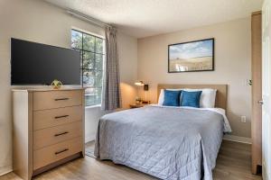 - une chambre avec un lit doté d'oreillers bleus et une télévision dans l'établissement InTown Suites Extended Stay Select Orlando FL - UCF, à Orlando