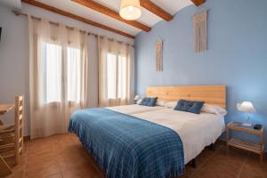 1 dormitorio con 1 cama grande y paredes azules en Pou De Beca Allotjaments i agroturisme en Vall dʼAlba