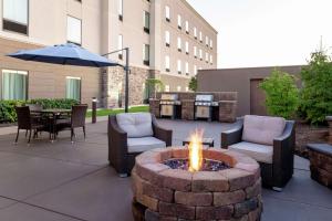 a fire pit with chairs and a table and an umbrella at Hampton Inn & Suites Wheeling - The Highlands in Triadelphia