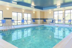 una piscina en una habitación de hotel con sillas azules en Hampton Inn & Suites Wheeling - The Highlands, en Triadelphia