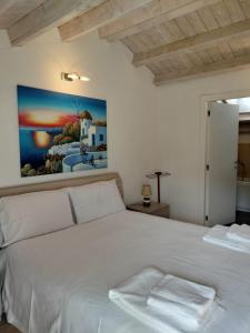 um quarto com uma cama branca e uma pintura na parede em La Darsena apartment em Peschiera del Garda