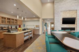 um lobby de um hospital com cadeiras azuis e uma tv em Homewood Suites by Hilton Houston NW at Beltway 8 em Houston