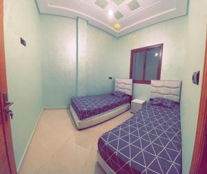 2 letti in una camera con letti viola di Dar Al Montazah a Meknès