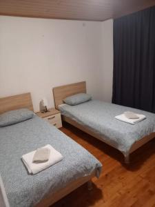 two beds in a room with two towels on them at Planinska kuća Rezo Rakitno in Posušje