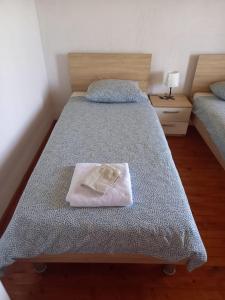 a bedroom with two beds with a towel on it at Planinska kuća Rezo Rakitno in Posušje