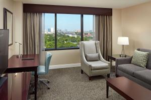 a living room with a couch and a chair and a window at Hilton Houston Plaza/Medical Center in Houston