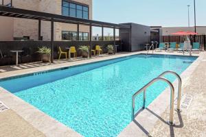 a large swimming pool with chairs and tables in a building at Home2 Suites By Hilton Sugar Land Rosenberg in Sugar Land