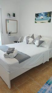 a white bed with pillows on it in a room at Tropical Suite in Benalmádena