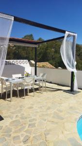 Un patio con una mesa y sillas en un tejado. en Tropical Suite, en Benalmádena