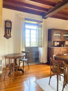 a dining room with a table and chairs and a clock at Casa do Viñal 