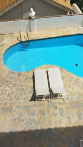 2 sillas de jardín sentadas junto a una piscina en Tropical Suite en Benalmádena