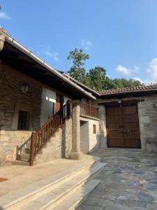 a stone house with a wooden door and a staircase at Casa do Viñal 