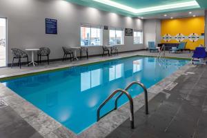 a large swimming pool with chairs and tables in a building at Tru By Hilton Cypress Houston TX in Cypress