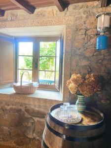 una habitación con una mesa con gafas y una ventana en Casa do Viñal 