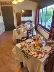 un comedor con dos mesas con comida. en Villa enza en Cinisi