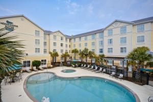 ein Hotel mit einem Pool vor einem Gebäude in der Unterkunft Homewood Suites by Hilton Wilmington/Mayfaire, NC in Wilmington